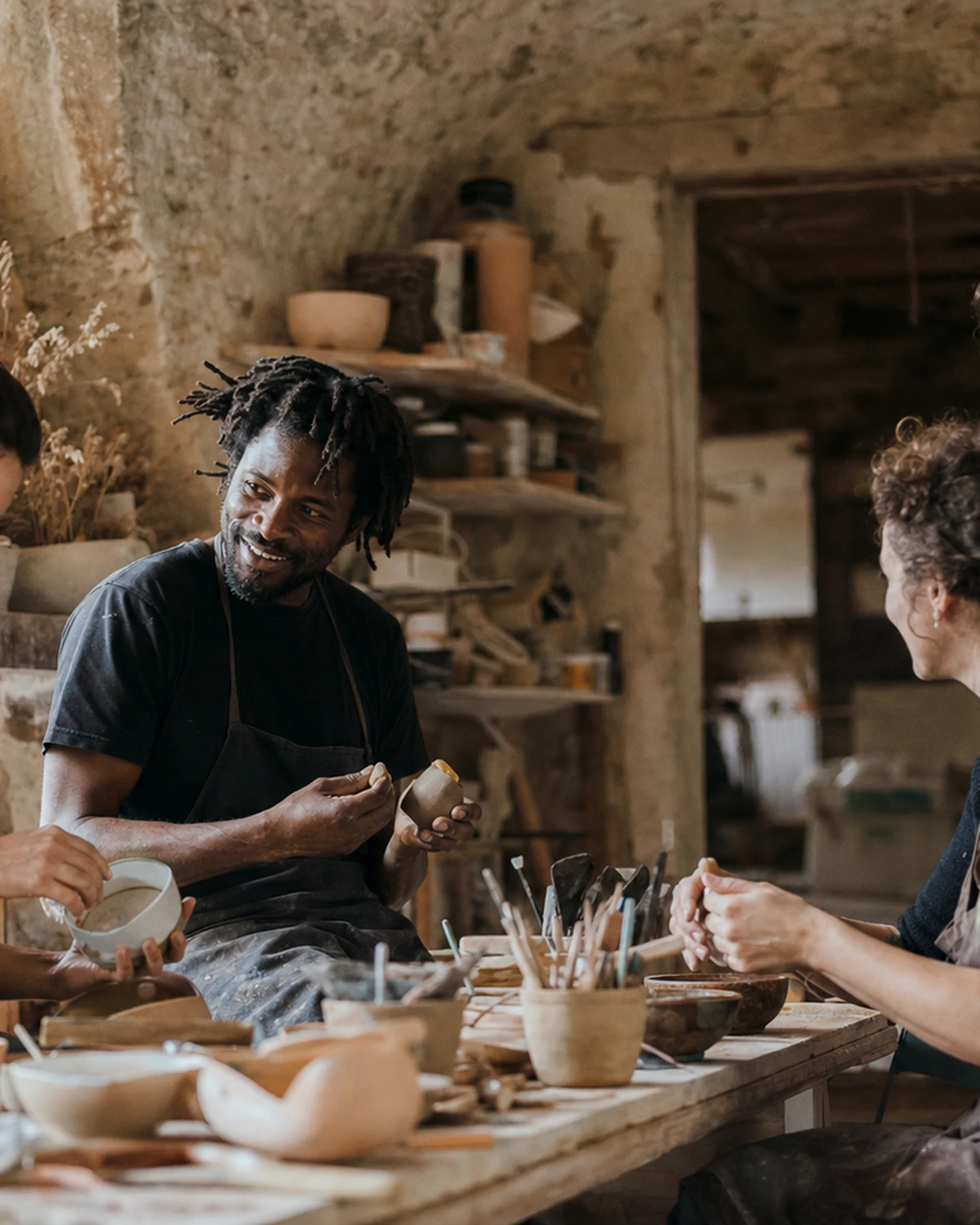 Illustrative scene of a team of artisans working together in a stone workshop with natural light.