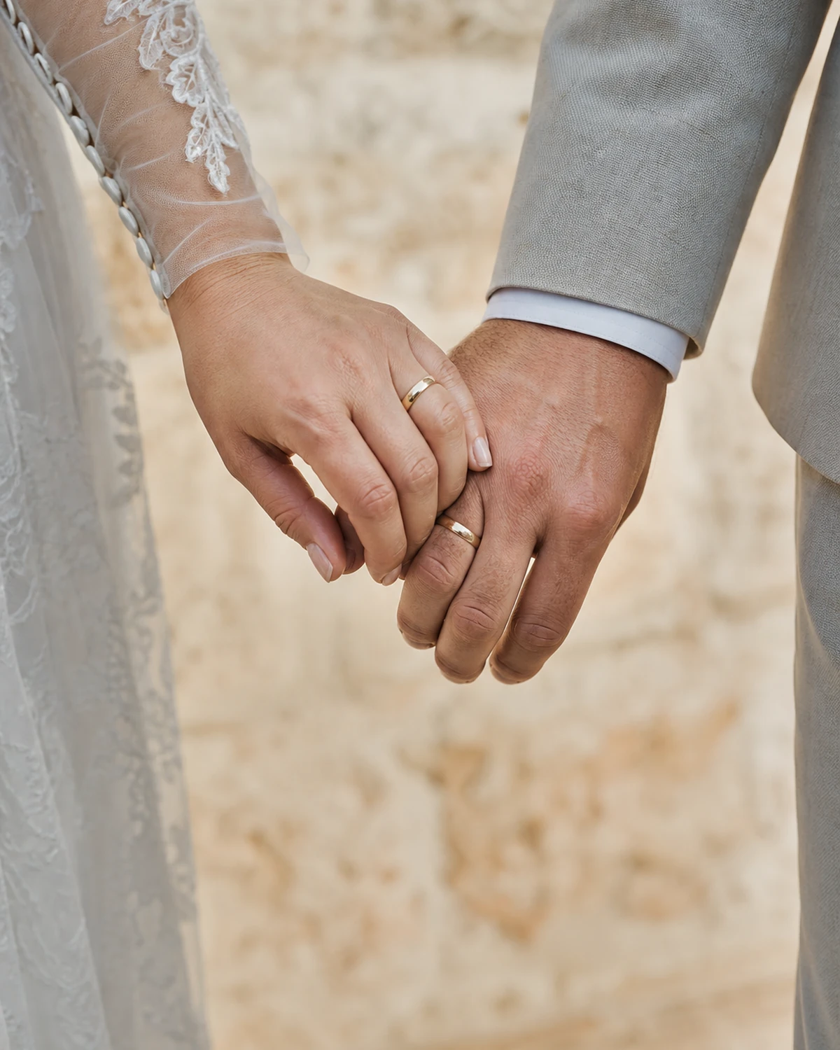 Escena ilustrativa de las manos unidas de una pareja recién casada, con alianzas visibles y luz suave.